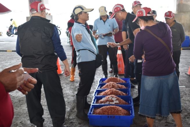 圖七、承銷人檢視櫻花蝦品質後寫下標單，再由拍賣員打開標單唱名價格