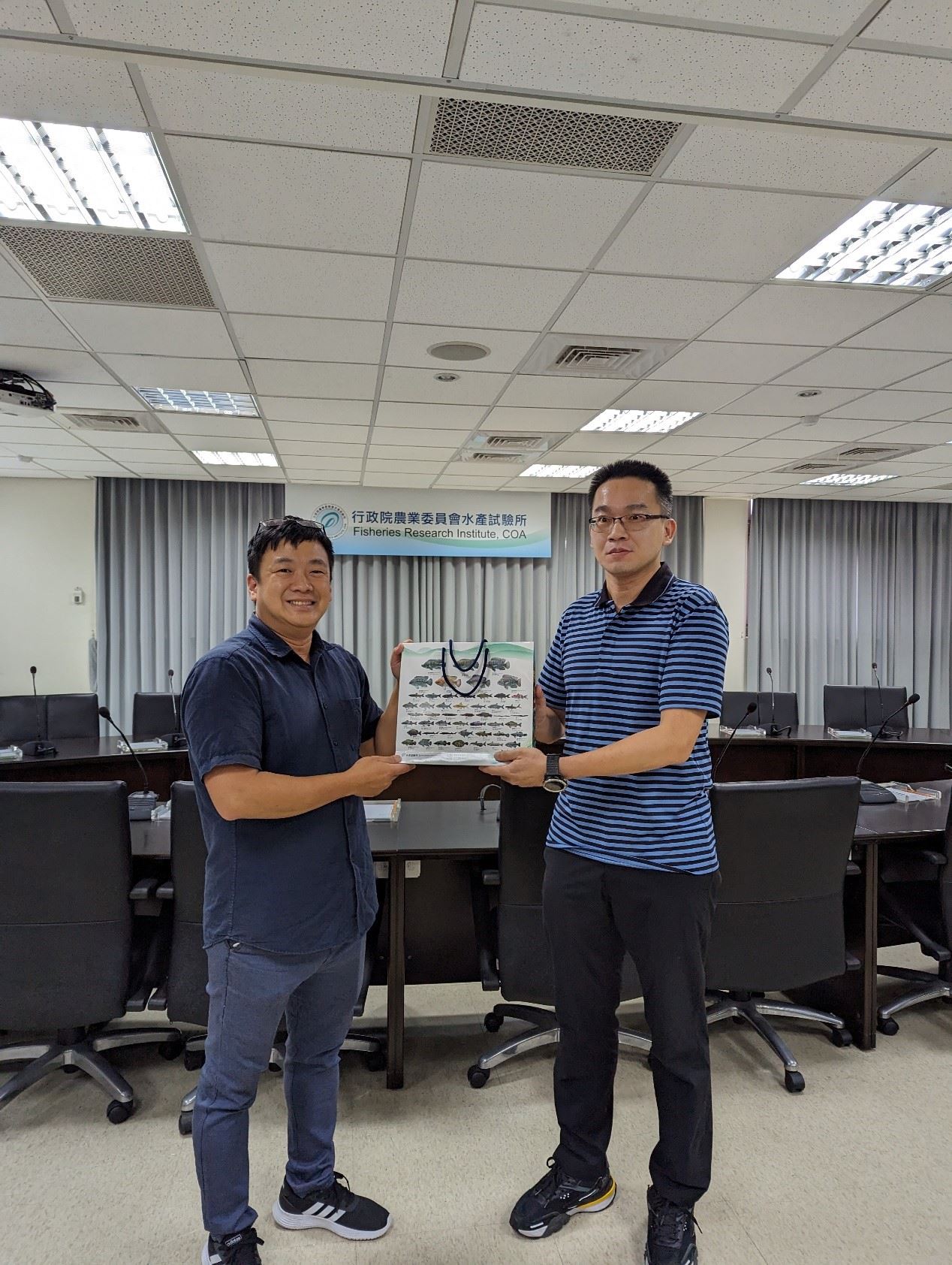 水產加工組張晏瑋副研究員代表致贈本所推廣品予蓋玉軒博士（左）
